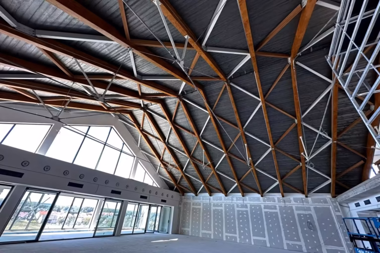 Belki stropowe w biurowcu oklejone laminatem architektonicznym w efekcie drewna