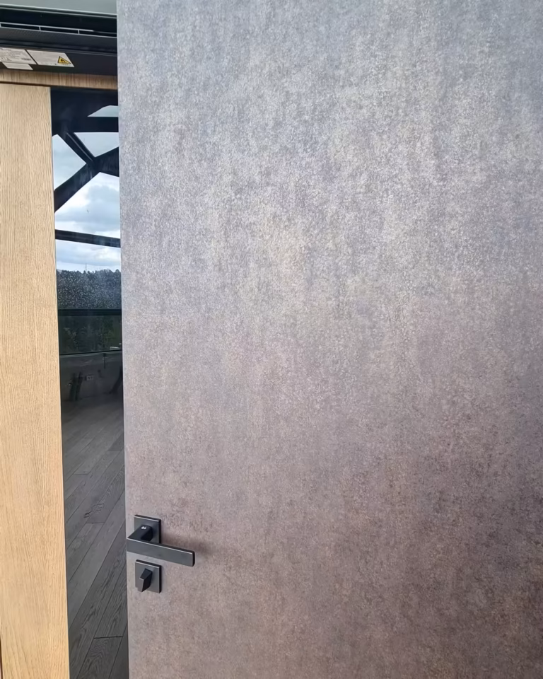 Drzwi odnowione laminatem architektonicznym w efekcie kamienia