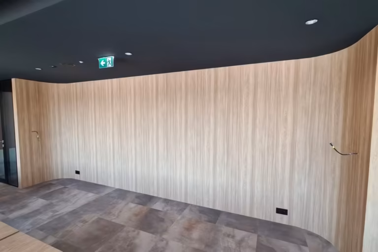 Ściana biura oklejona laminatem architektonicznym w efekcie drewna